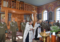 Duchowni prawosławni i wierni w mundurach stoją w cerkwi