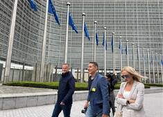 Dziennikarze idą wzdłuż europarlamentu.