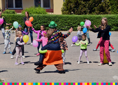Grupa dzieci w tańcu, w rękach trzymają baloniki