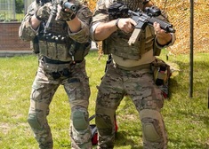 Dwaj mężczyźni w mundurach strzelają z broni