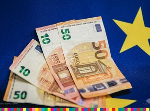 Banknoty euro leżące na niebieskiej fladze