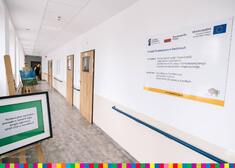 Korytarz w budynku z tablicą informacyjną projektu unijnego, w ramach którego sfinansowali budowę ośrodka