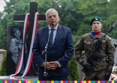 Bogusław Dębski, przewodniczący Sejmiku przemawia. Za jego plecami warta honorowa przy grobie ks. Suchowolca