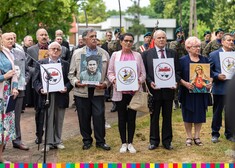 Dawni działacze opozycji antykomunistycznej trzymają plansze z wizerunkiem ks. Suchowolca, Matka Bożą oraz logotypem klubu WIR