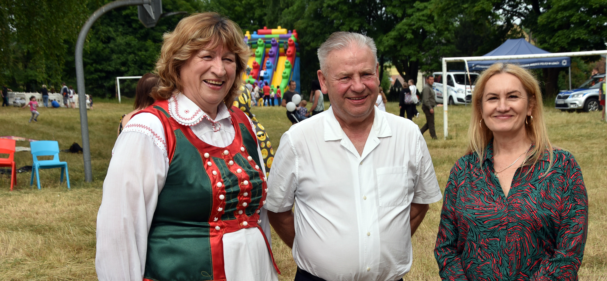 Wicemarszałek Marek Olbryś stoi na zdjęciu z kobietą w stroju ludowym oraz dyrektor WOPiT