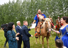 Mężczyzna siedzący na koniu, obok kilka osób