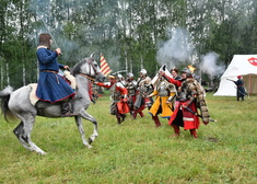 Mężczyzna siedzący na koniu, obok atakujący mężczyźni