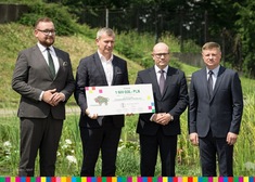 Burmistrz Łap Krzysztof Gołaszewski trzyma czek w obecności panów marszałków