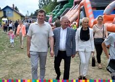 wicemarszałek Marek Olbryś wraz z małżonką i mężczyzną idą razem obok atrakcji dla dzieci 