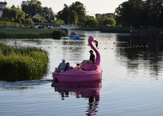 Kilka osób pływa na łódce w kształcie flaminga