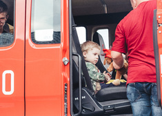 Dziecko siedzące w wozie strażackim