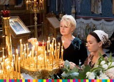Członek zarządu Wiesława Burnos zapala symboliczną świeczkę wewnątrz Monasteru