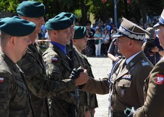 Mężczyzna w mundurze skałada gratulacje żołnierzom 