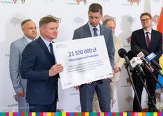 Dariusz Piontkowski i Marek Malinowski trzymają czek na 21,5 mln. zł.