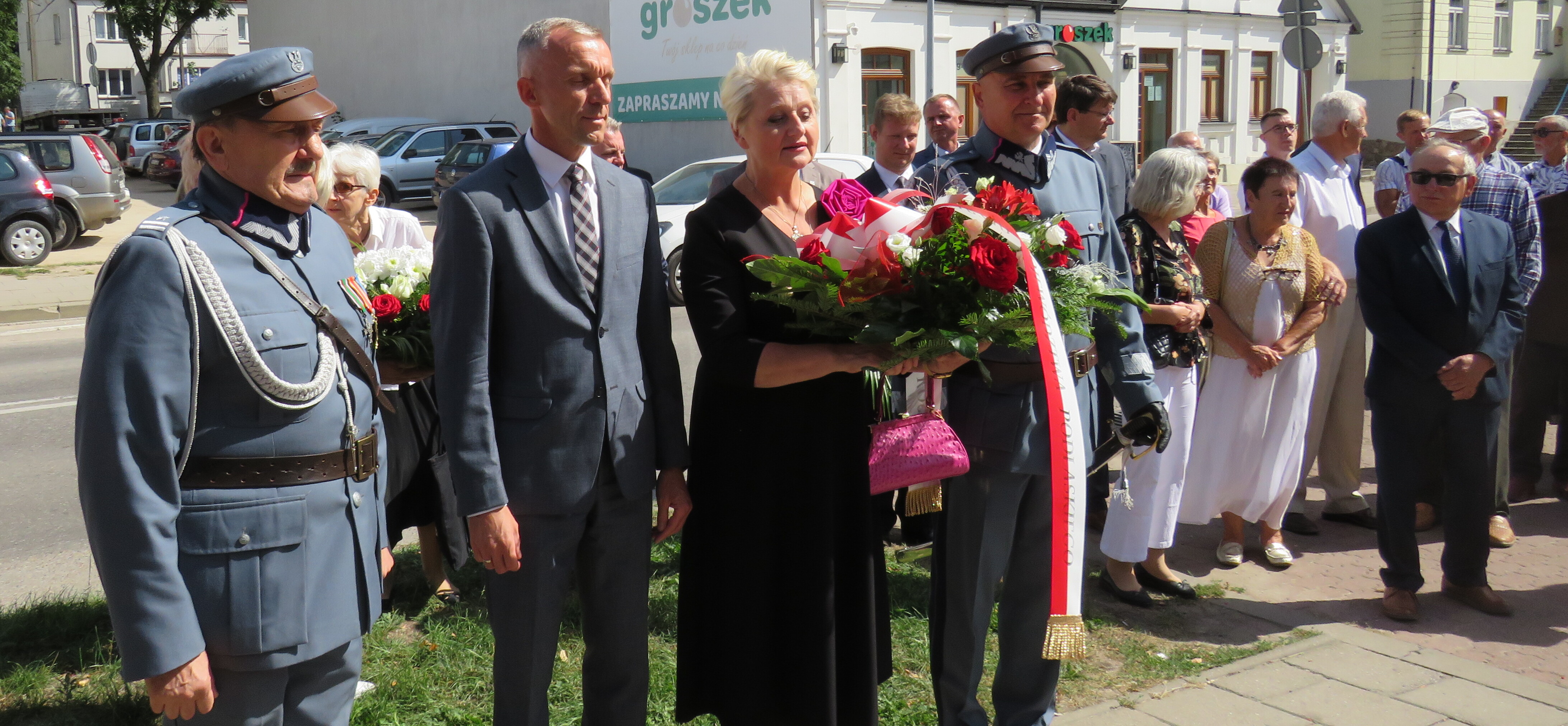 grupa osób podczas składania kwiatów, wśród nich członek zarządu, Wiesława Burnos