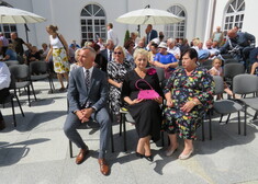 osoby siedzące na krzesłach w trakcie uroczystości 
