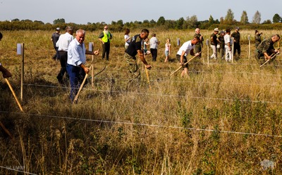 Uczestnicy sianokosów koszą łąkę