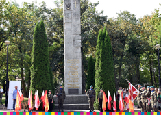 Zołnierze i flagi przed pomnikiem