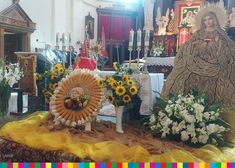 Kwiaty i wieniec dożynkowy na ołtarzu w kościele