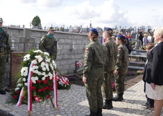 Wiesława Burnos oraz żołnierze pod tablicą pamięci