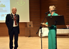 Prezes Zawadzki oraz kobieta w zielonym ubraniu na scenie