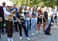 uczestnicy trzymają swoje psy na rękach