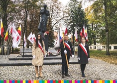 Kilka osób stojących przed pomnikiem