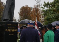 Wiesława Burnos, członek zarządu województwa oddaje hołd pod pomnikiem wraz z mężczyznami w mundurach 