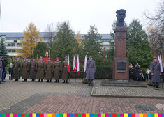 przedstawiciele służb mundurowych stoją pod pomnikiem