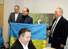 Marek Olbryś trzymający z drugim mężczyzną ukraińską flagę