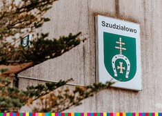 Skrawek zewnętrznej ściany z herbem gminy Szudziałowo