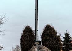 Pomnik złożony z dużego głazu, tablicy pamiątkowej oraz dużego metalowego krzyża