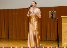 młoda kobieta w złotej sukni podczas występu artystycznego 