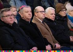 Grupa osób siedzących w kościelnych ławach