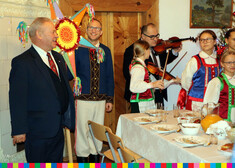 Wicemarszałek Marek Olbryś, po prawej stronie kobiety w strojach ludowych, dziewczynka i mężczyzna grają na skrzypcach, po lewej stronie mężczyzna w stroju ludowym, trzyma kolorową gwiazdę 