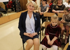 Wiesława Burnos siedząca w krześle, obok mała dziewczynka