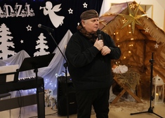Mężczyzna w czapce harcerskiej na tle wystroju bożonarodzeniowym  