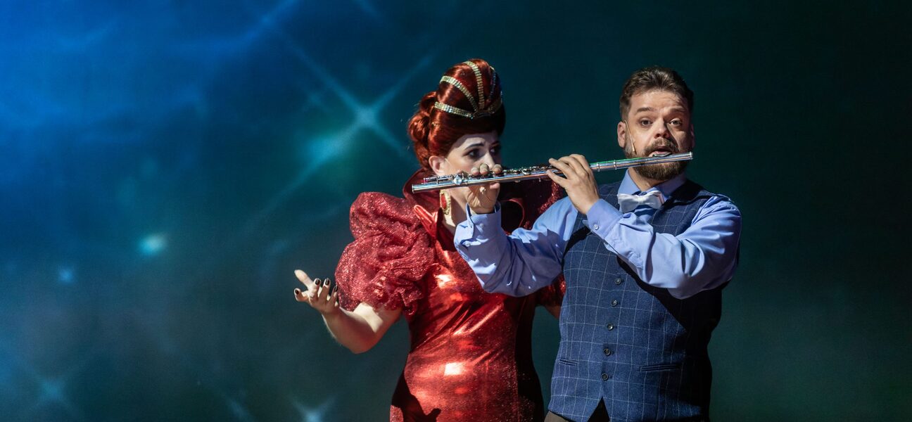 Kobieta i mężczyzna na scenie, mężczyzna gra na flecie