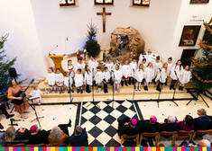 Dziecięcy chór śpiewający kolędy i pastorałki na tle żłobka betelejmskiego