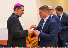 Członek zarządu Marek Malinowski symbolicznie dzielącym się opłatkiem z Biskupem Drhiczyna