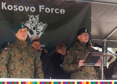Przemawiający mundurowy, na tle blandeką z napisem Kosovo Force