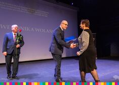 Artur Kosicki gratuluje kobiecie w czarno beżowej sukience