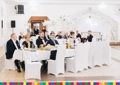 Dyrektor Jabłoński i inni uczestnicy balu siedzą przy stołach.