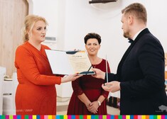 Kobieta przekazuje dyplom Robertowi Jabłońskiemu