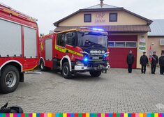 Wóz strażacki, w tle widoczna jednostka OSP