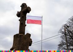 Krzyż na tle flagi polskiej.