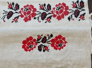 Biały ręcznik z wyszytymi czerwonymi różyczkami