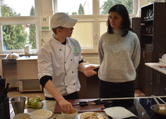 Uczeń przyrządza danie, obok kobieta