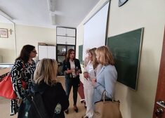 Pięć kobiet rozmawiają ze sobą w sali szkolnej