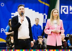 Gospodarz oraz dyrektor Jóczykowska stoją na tle biało niebieskiego logotypu województwa podlaskiego